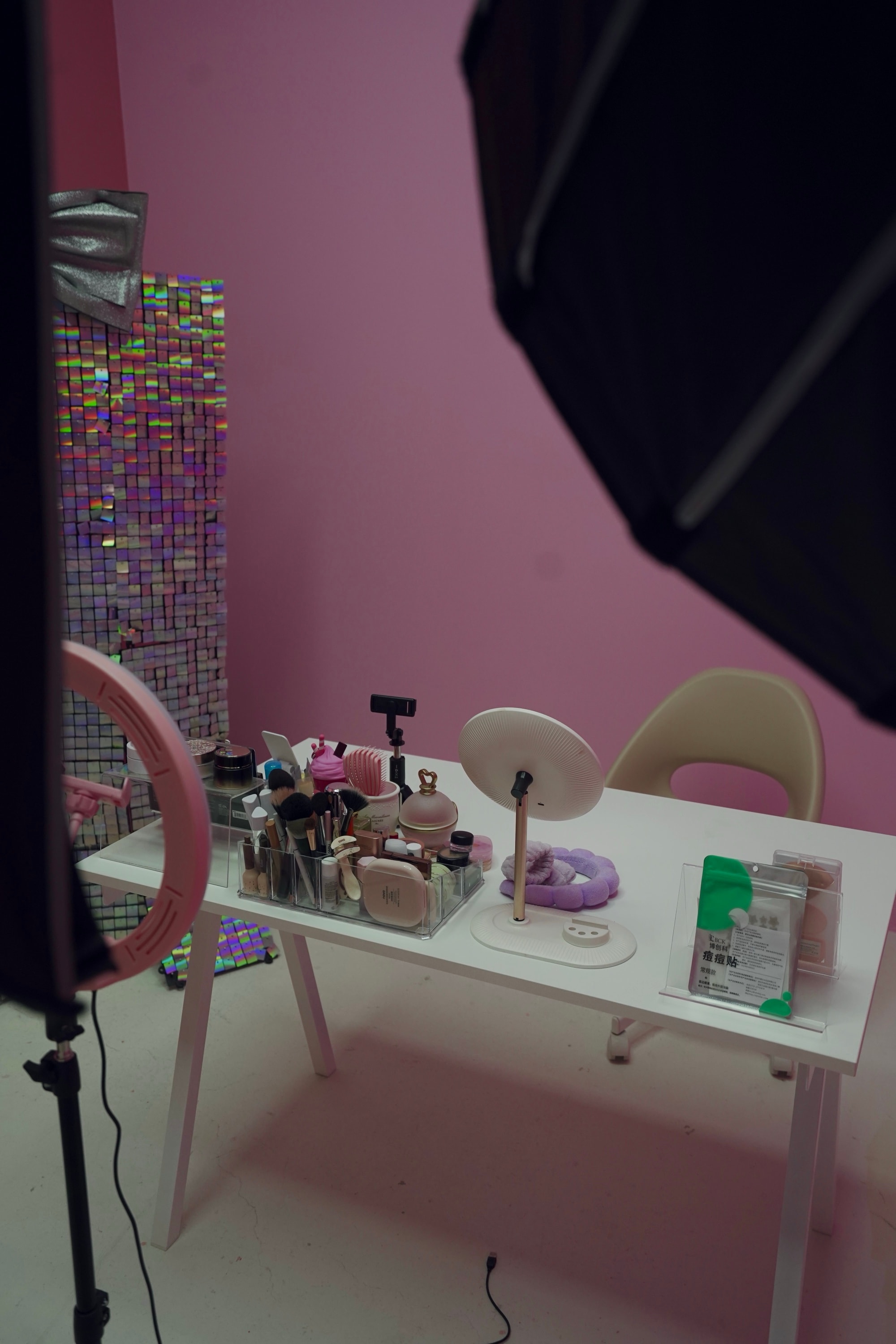 Beauty live-streaming room — a cosmetics vanity and ring light against a pink sequinned backdrop