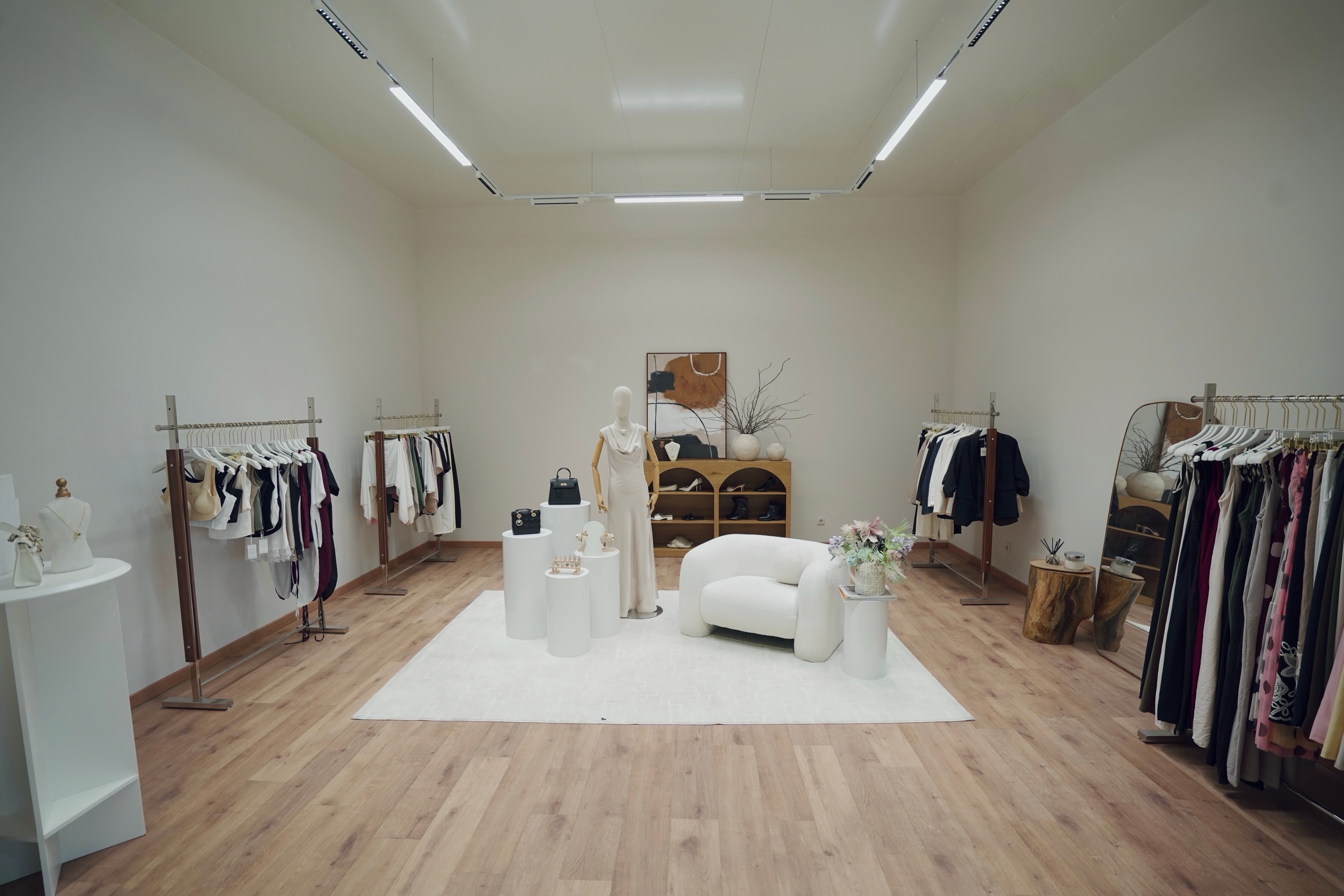 PROFECIABRAND showroom in Árvore — clothing rails, a styled mannequin and bouclé seating where live-commerce shipments are curated